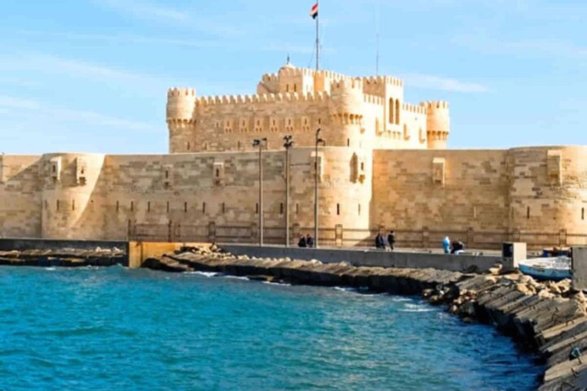 un grande castello con acqua blu di fronte