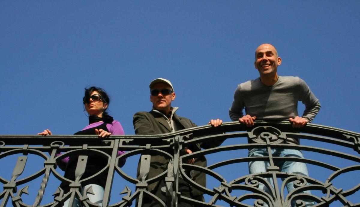 tres persones dempeus a sobre d'una tanca