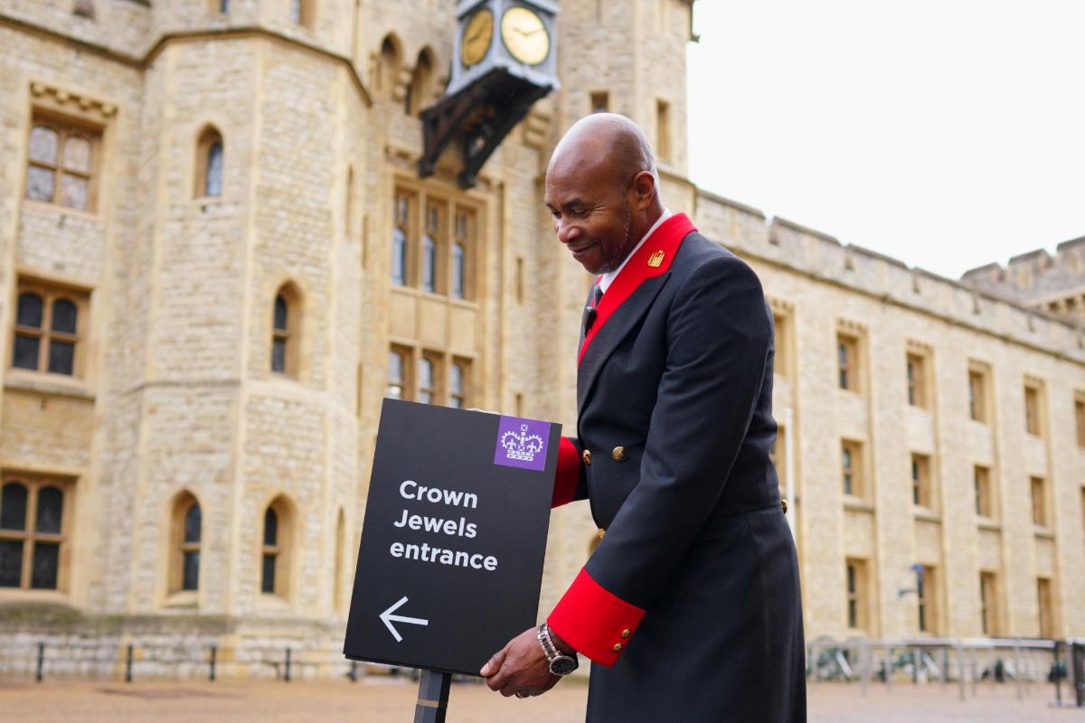 a man in a suit holding a sign in front of a building
