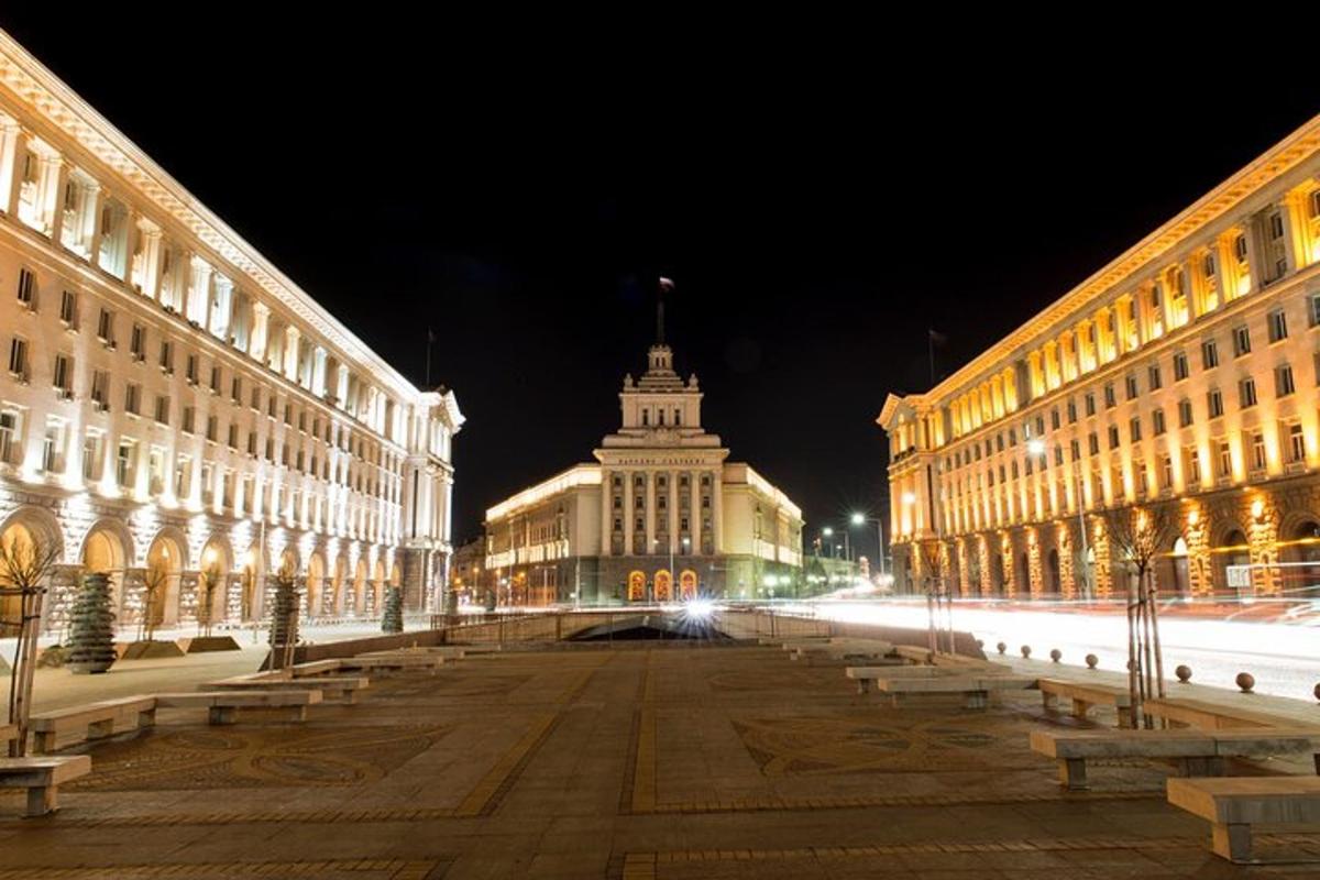 Městská ulice v noci s budovami a lavičkami