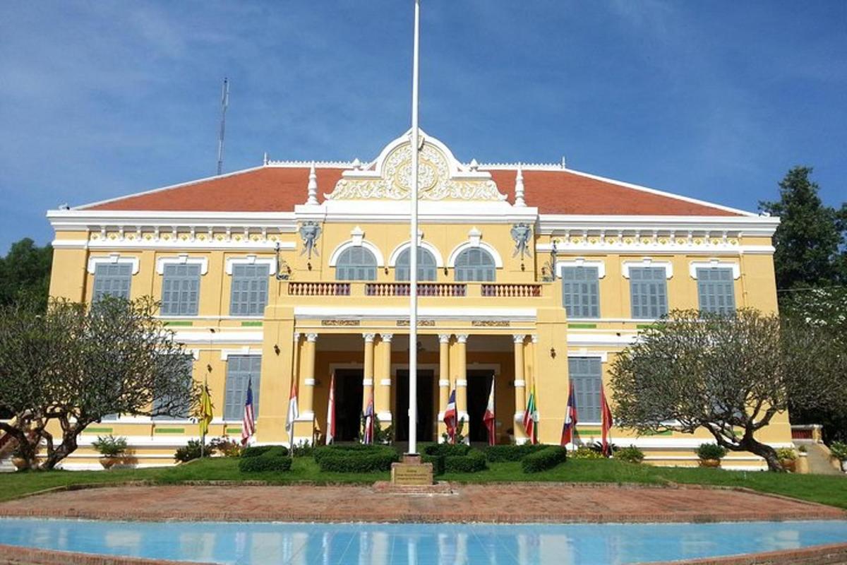 một tòa nhà lớn màu vàng có đài phun nước ở phía trước