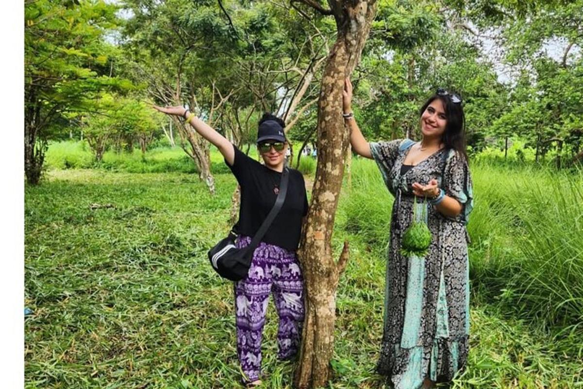 dua orang wanita berdiri di sebelah pokok