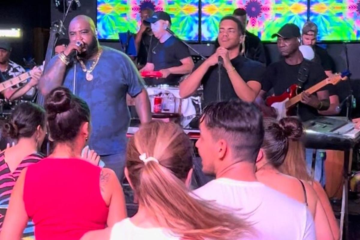 um grupo de pessoas cantando e tocando instrumentos em uma banda
