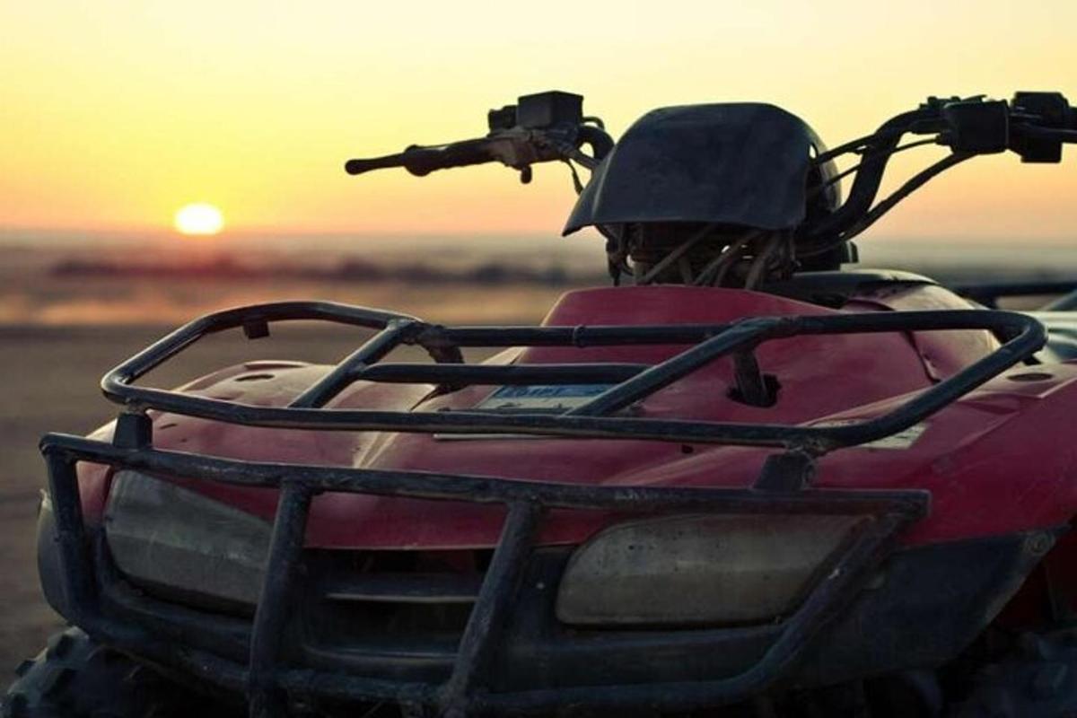 una persona in sella a un quad al tramonto