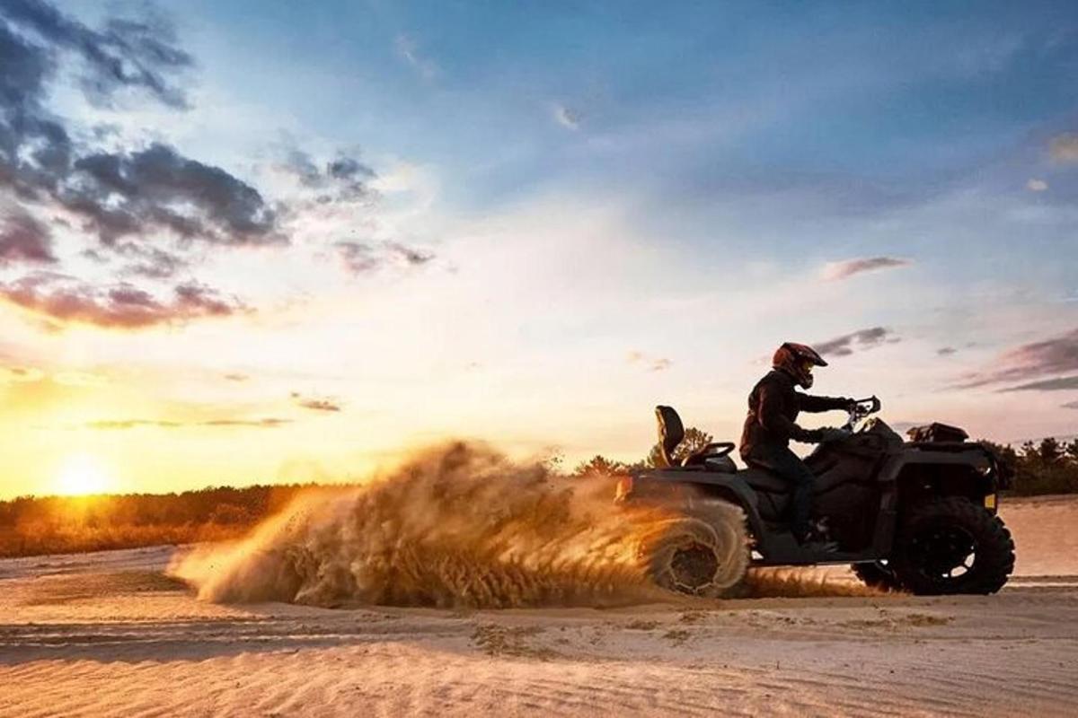un uomo in sella a un quad sulla sabbia