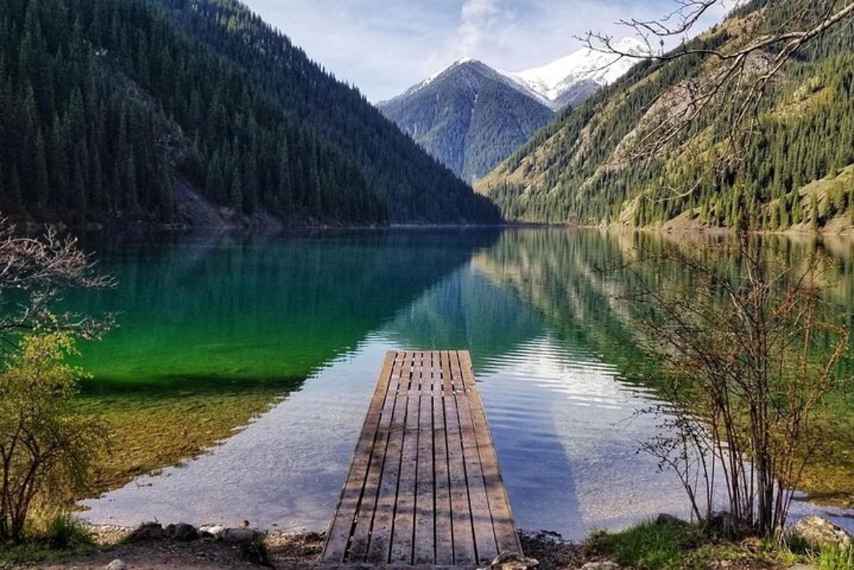 a dock in the middle of a lake with mountains