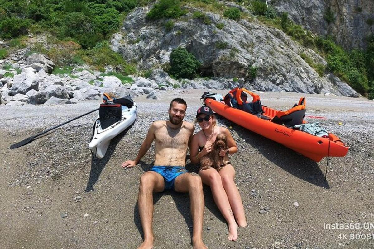 moški in ženska sedita na plaži ob čolnu