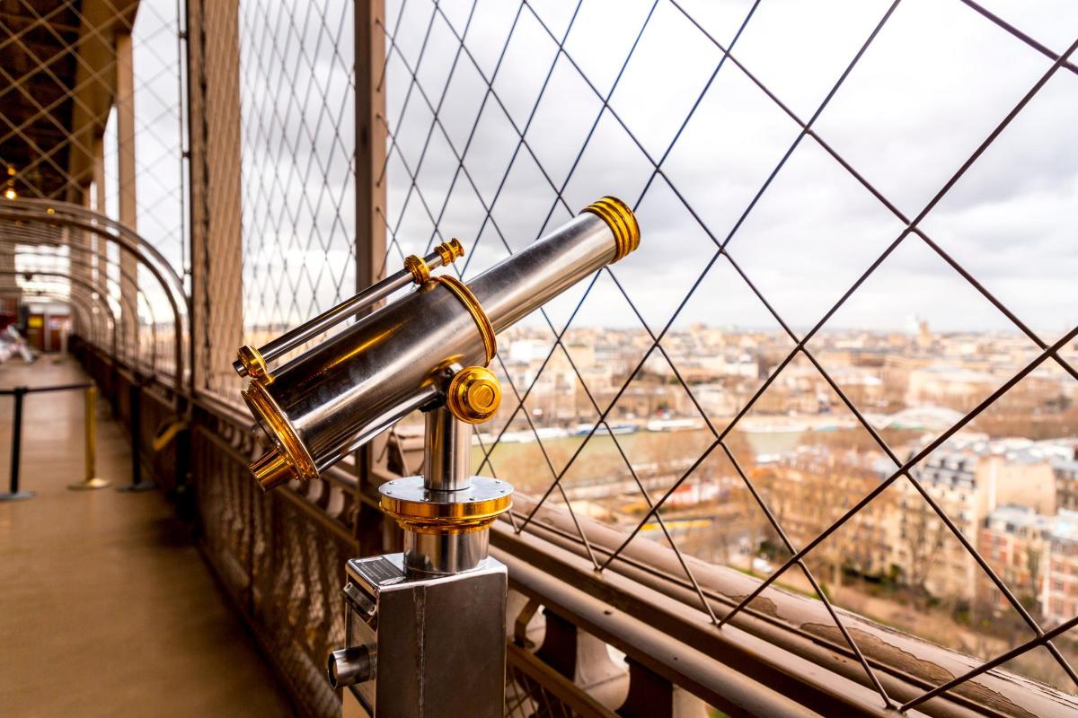 a telescope on the brooklyn bridge looking out at the city