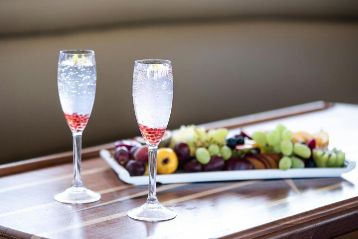 due bicchieri di champagne su un tavolo con un piatto di cibo
