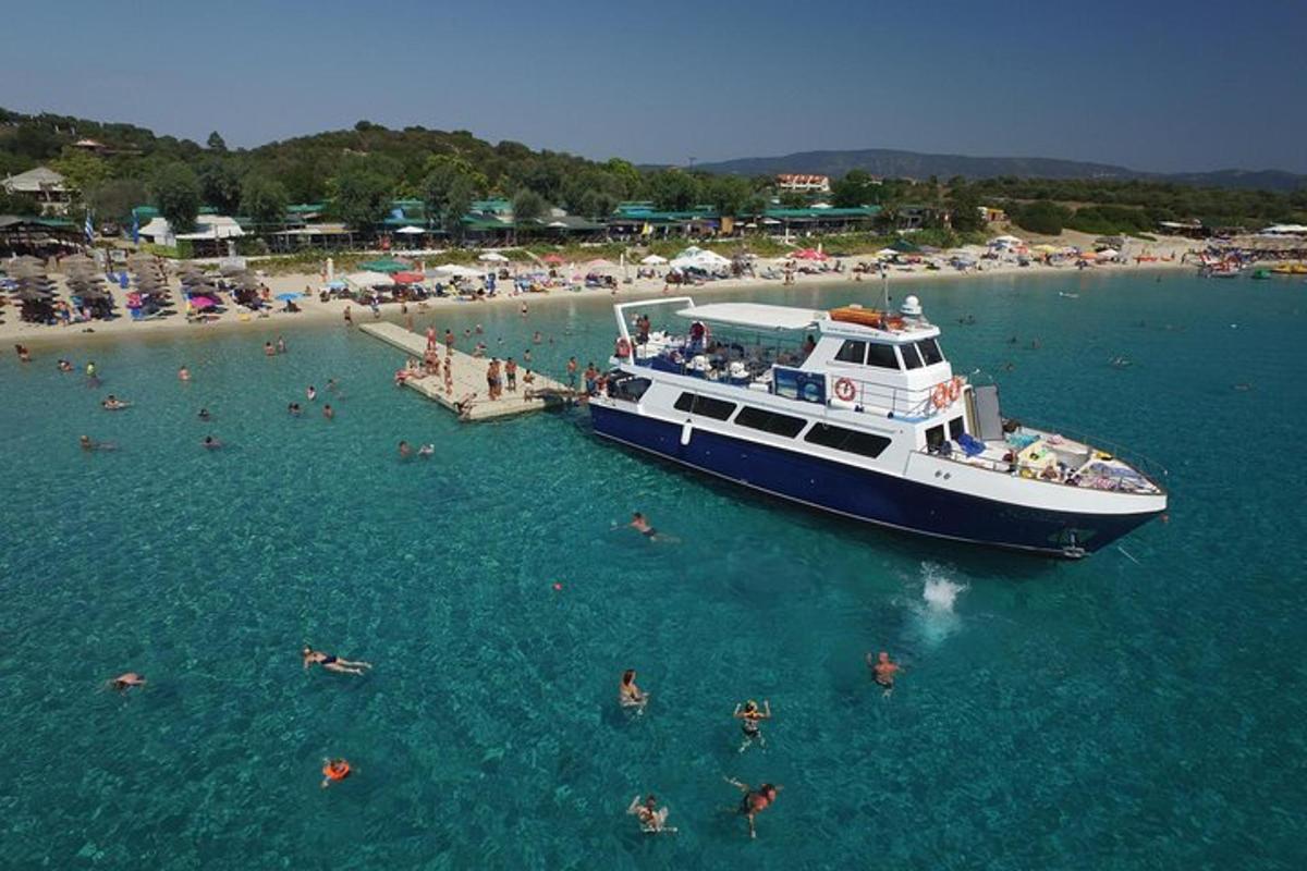 a boat in the water near a beach with people