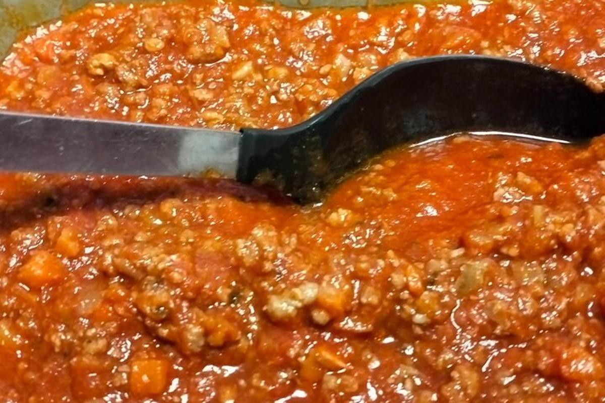 a spoon in a chili dish with sauce