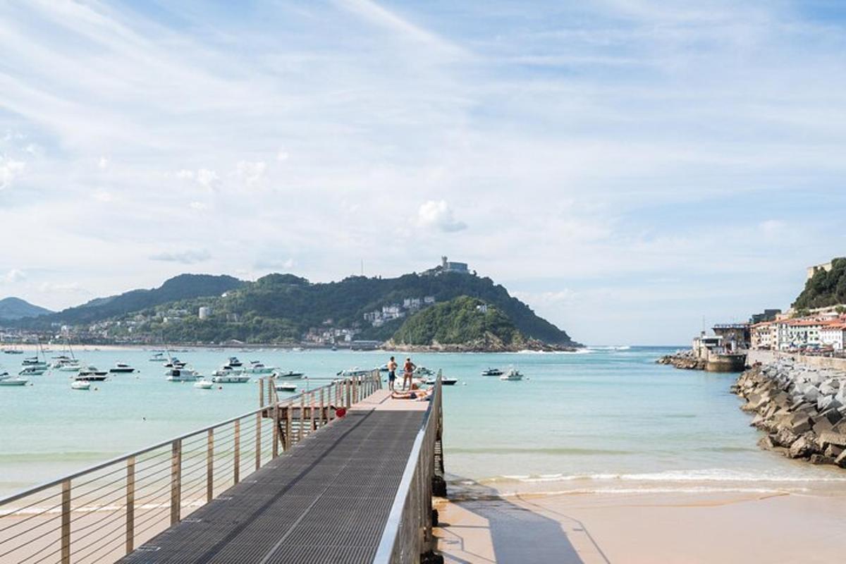 a pier on a beach with boats in the water