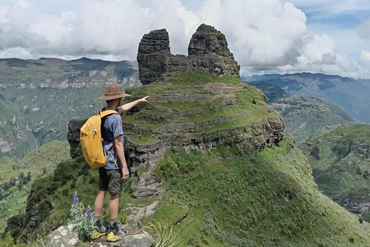 a man with a backpack standing on top of a mountain