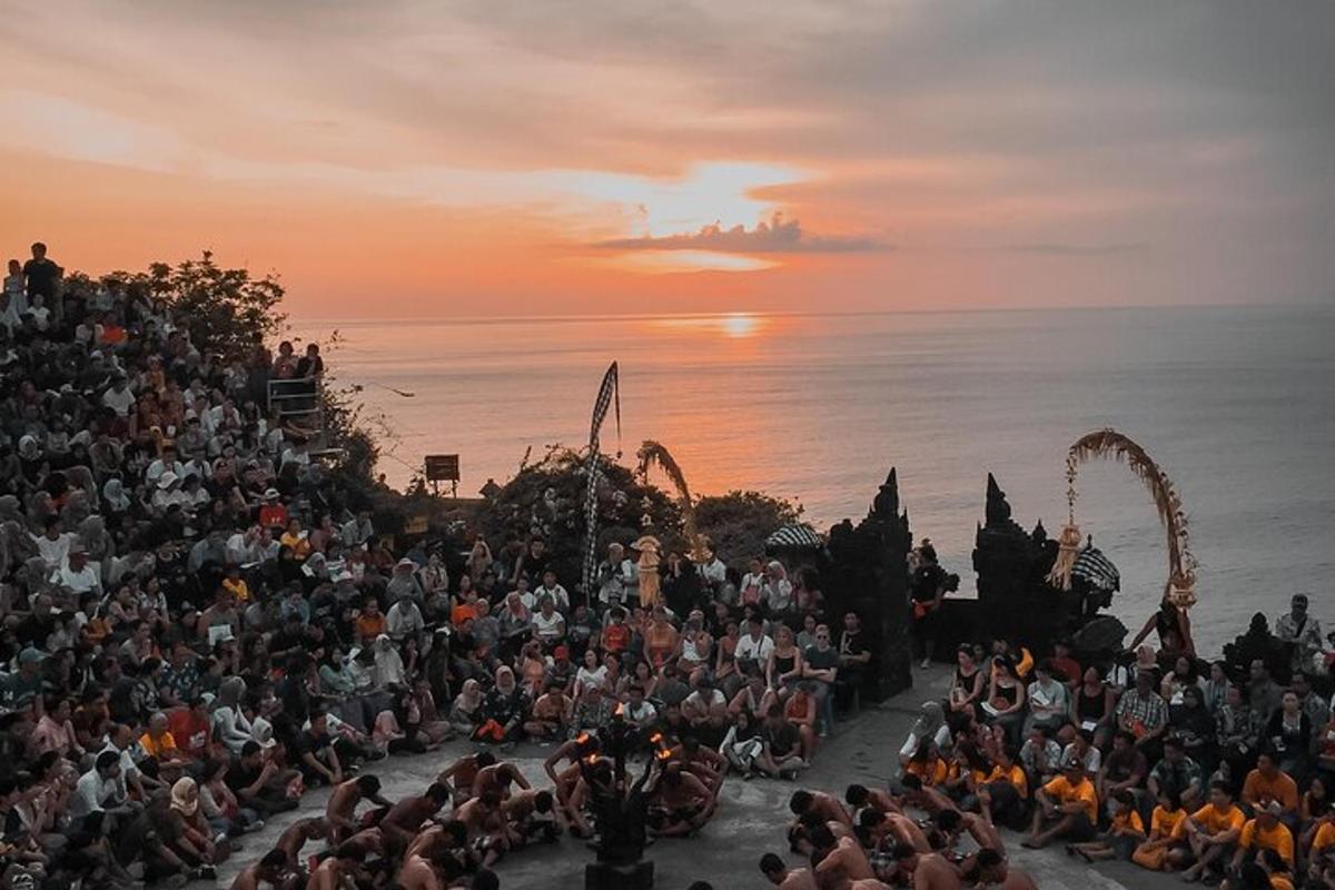 una grande folla di persone che guardano uno spettacolo al tramonto