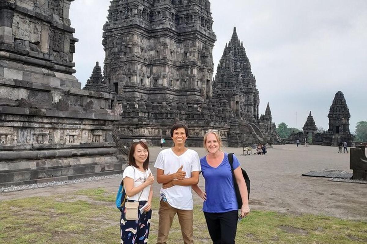 tres personas de pie frente a un templo