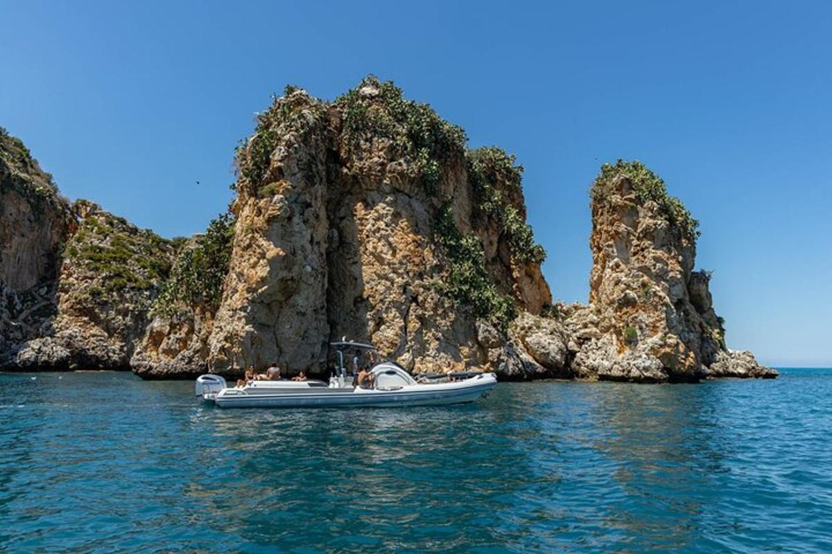 μια βάρκα στο νερό κοντά σε ένα βραχώδες νησί
