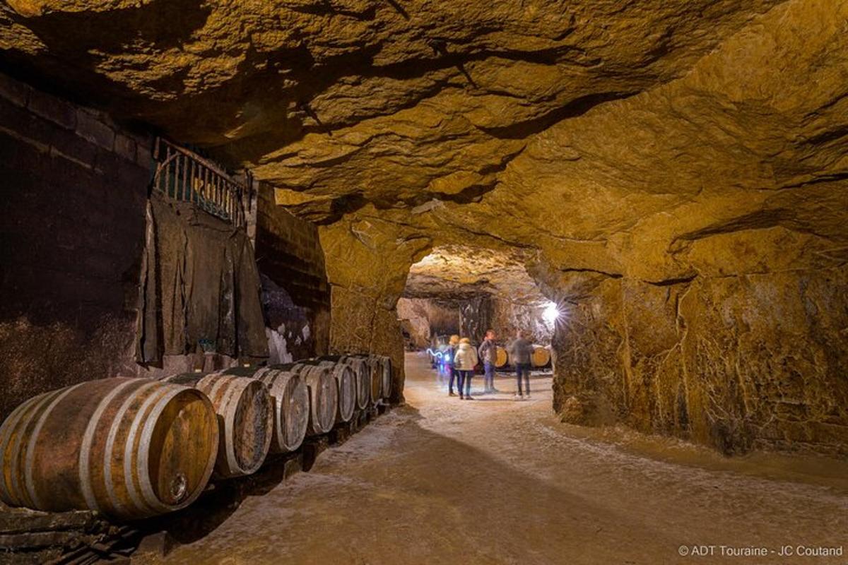 a group of people walking through a cave with barrels