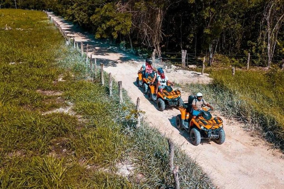 a group of people riding on atvs on a dirt road