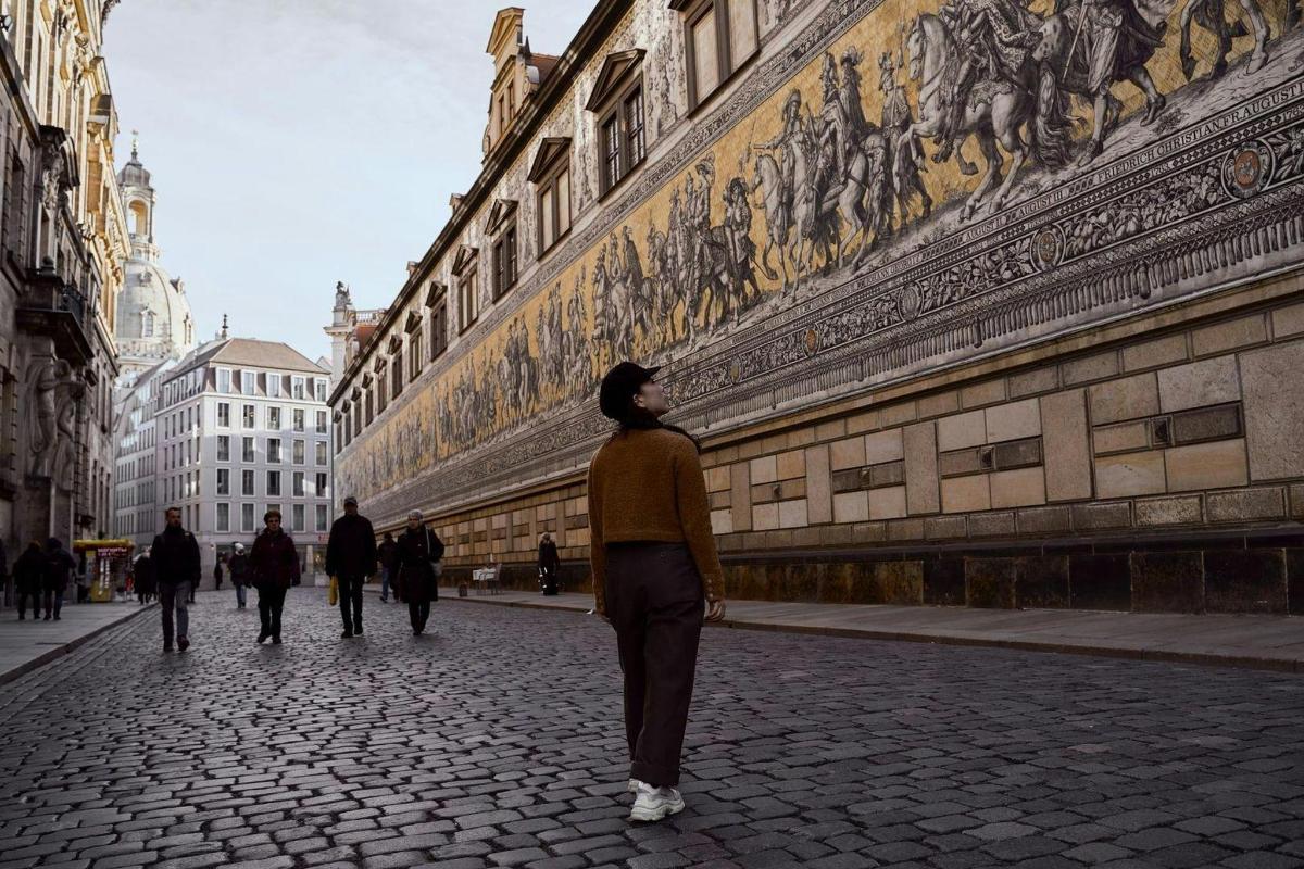 una dona caminant per un carrer al costat d'un edifici