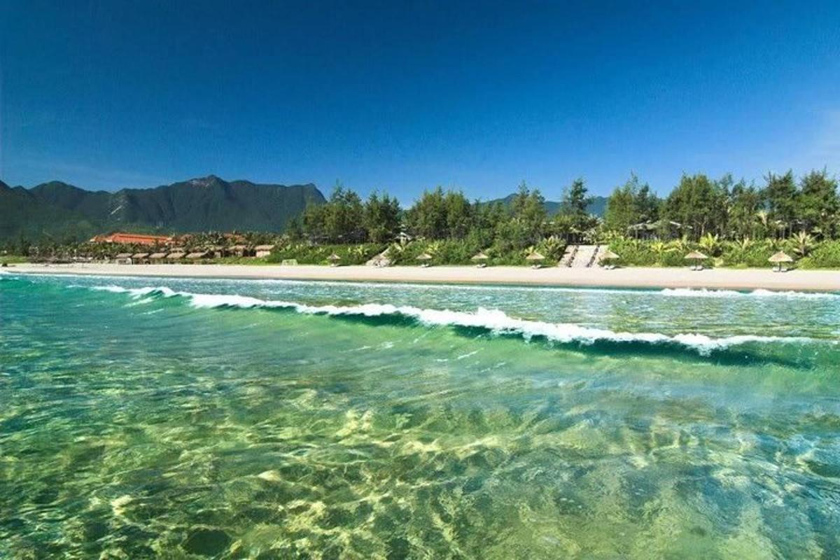 ένα υδάτινο σώμα με παραλία με δέντρα και βουνά