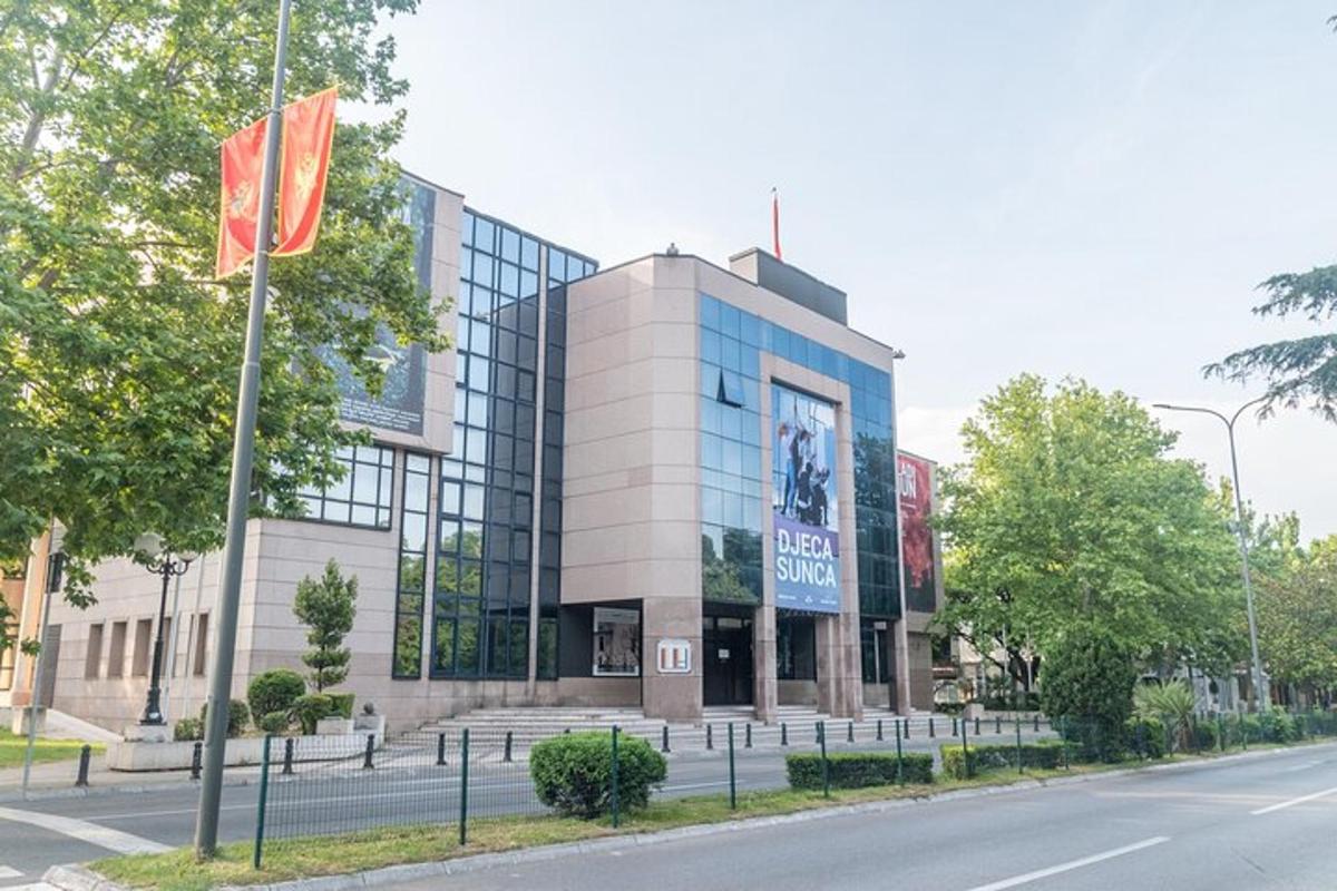 ένα κτίριο με δύο σημαίες μπροστά από έναν δρόμο