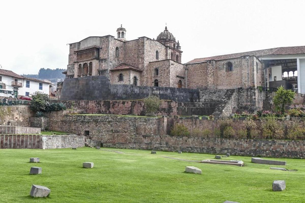 un vecchio castello con un campo verde di fronte
