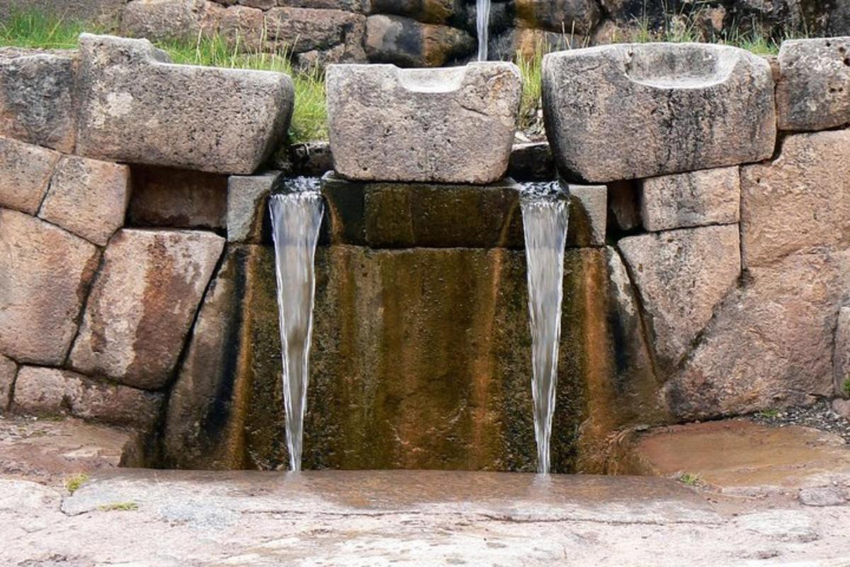 una fontana d'acqua in un muro di pietra
