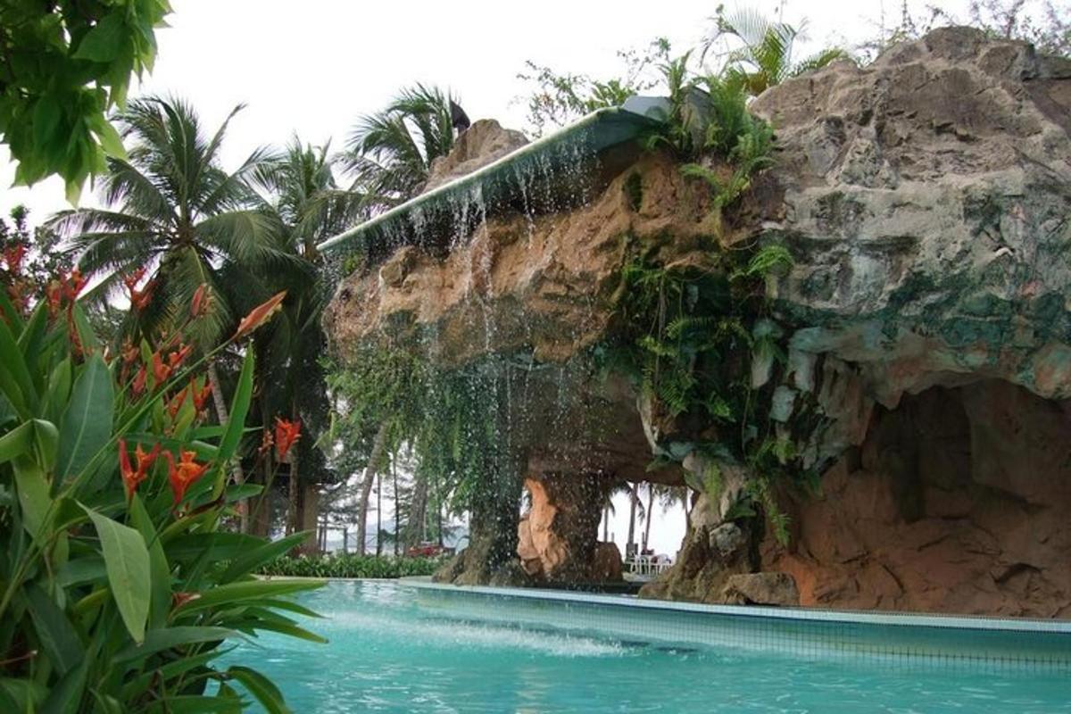 a pool in a resort with a rock wall
