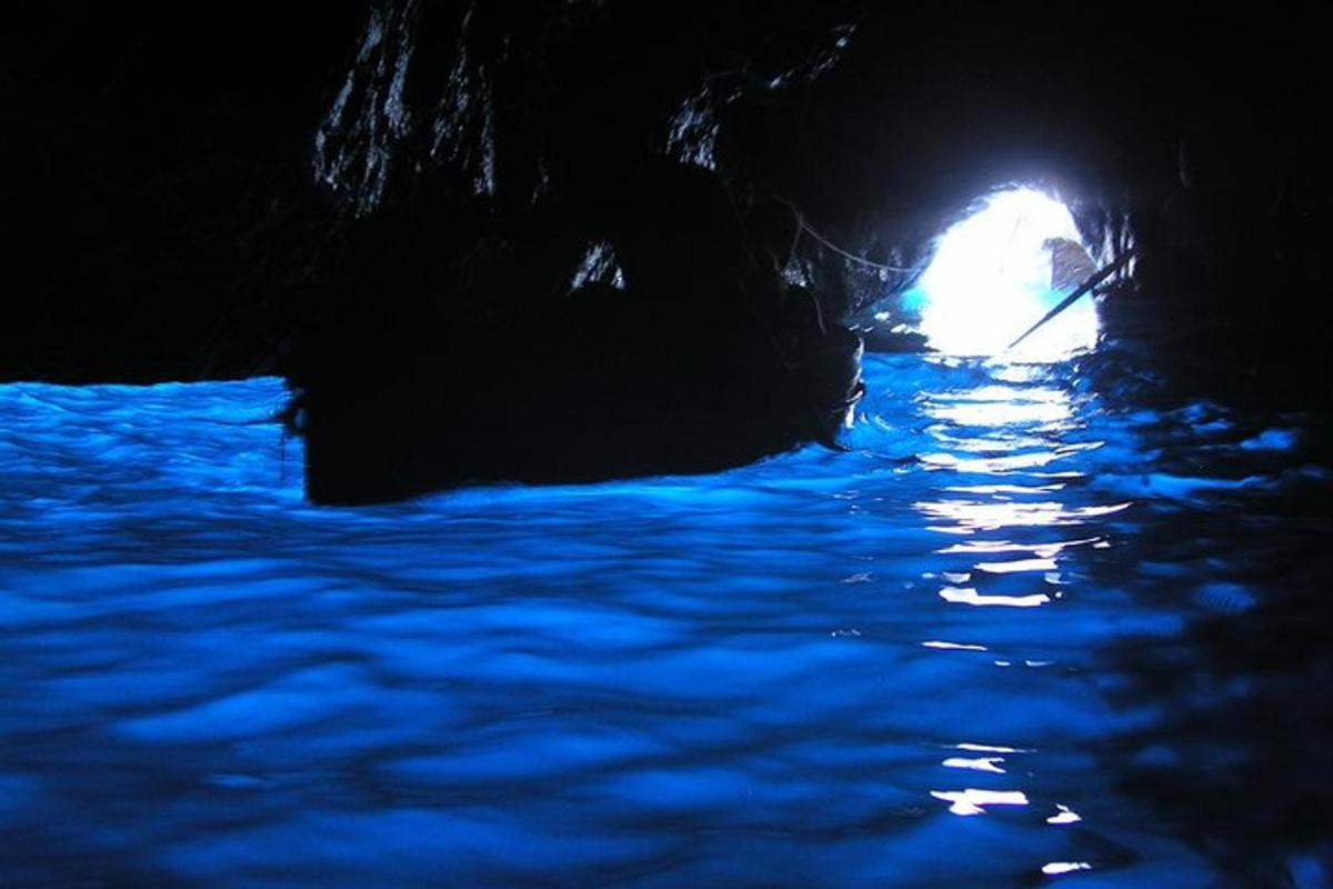 a boat in a cave with a light in the background
