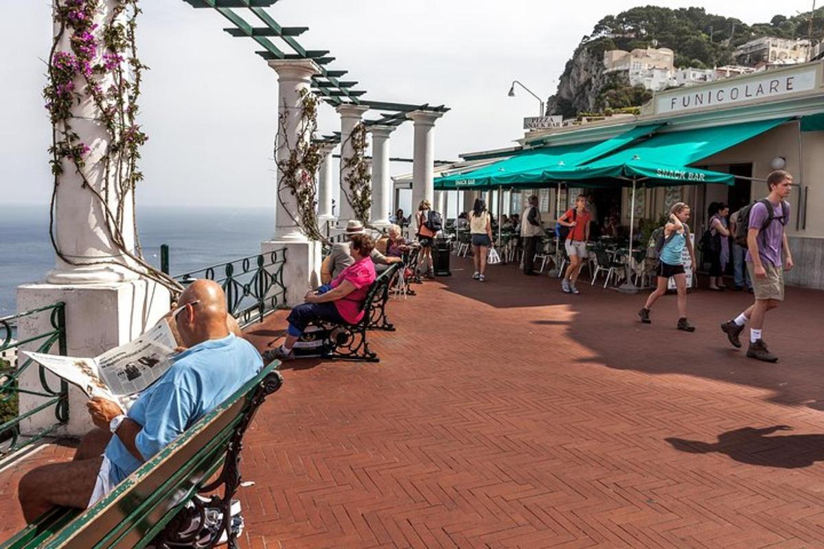 un home assegut en un banc al costat de l'oceà