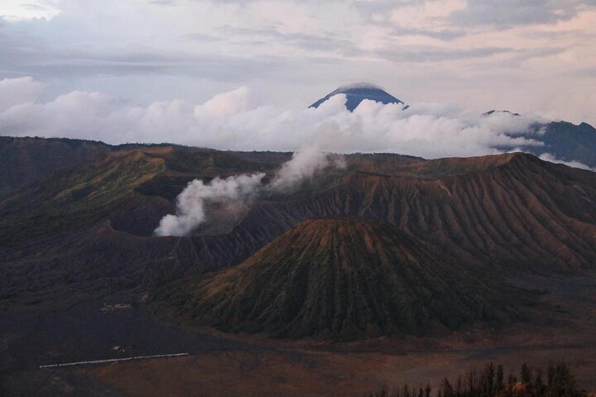isang eroplano ang lumilipad sa ibabaw ng bundok na may mga ulap