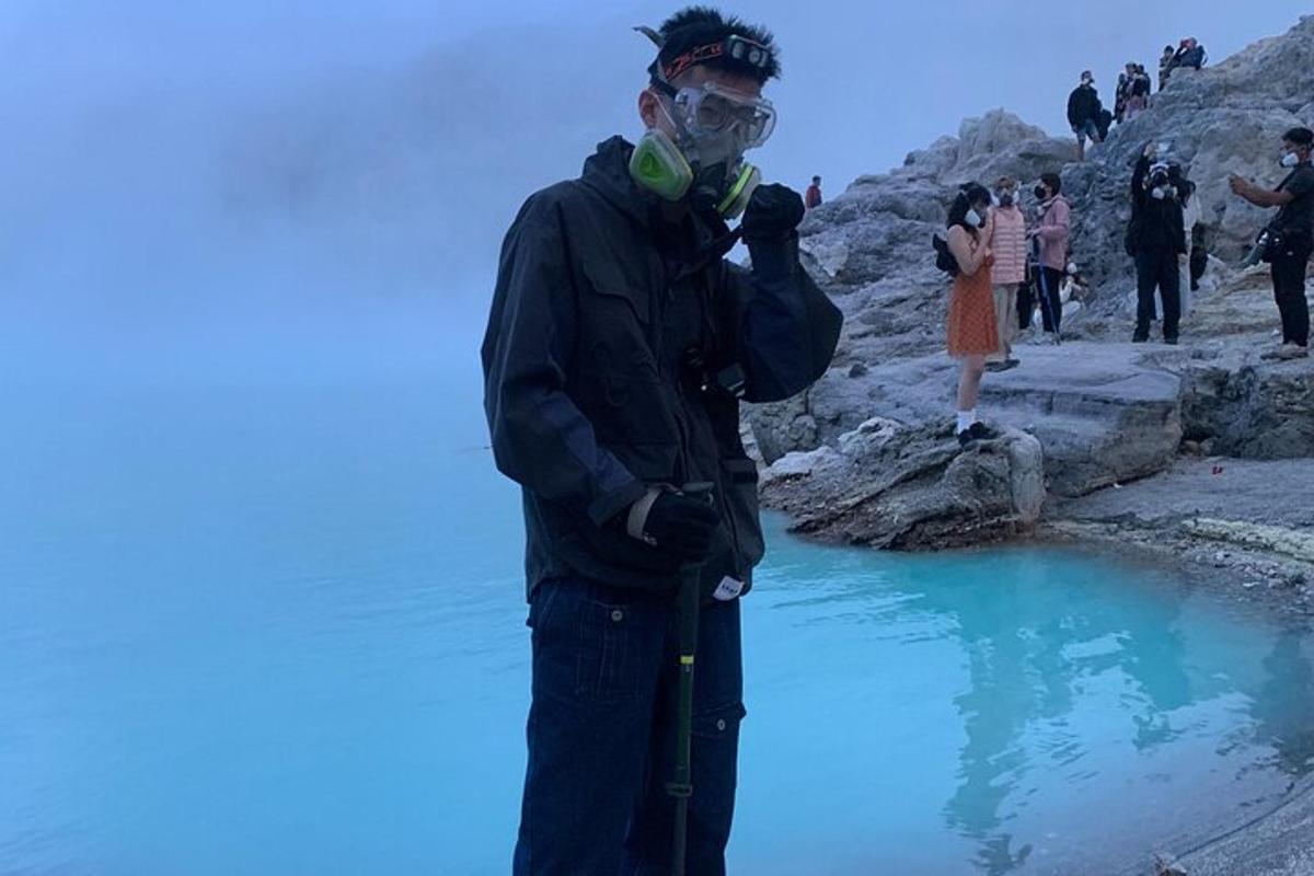 un home amb una màscara dret al costat d'una bassa d'aigua