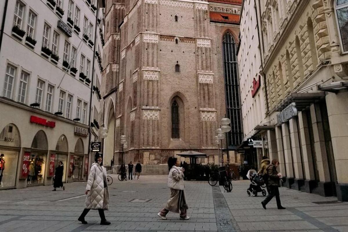 Dos personas caminando por una calle frente a un edificio.