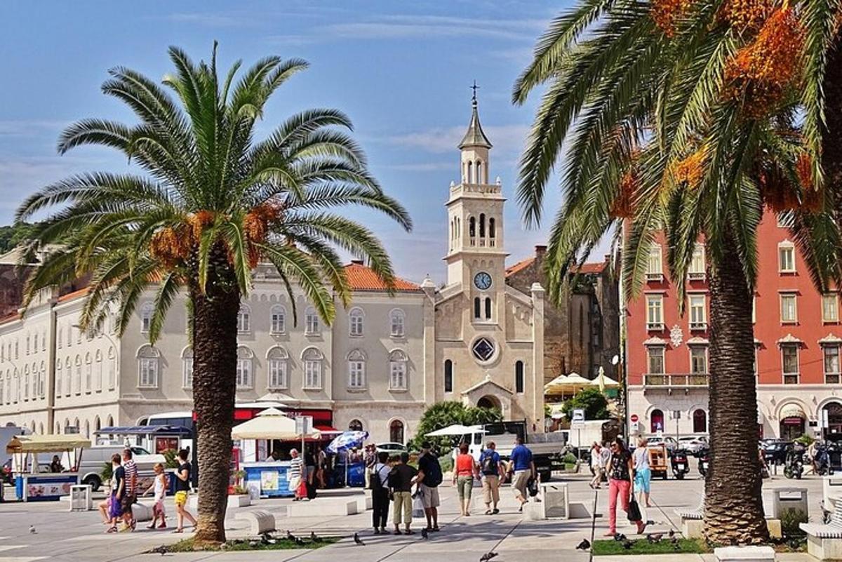a large building with a clock tower and palm trees