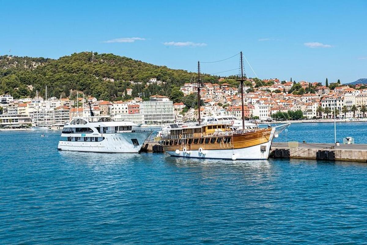 Tres barcos están atracados en el agua cerca de una ciudad.