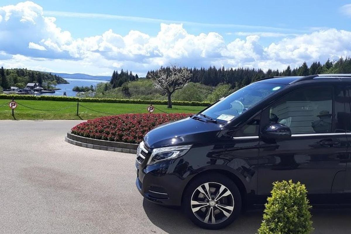 Ένα μαύρο SUV παρκαρισμένο σε ένα δρόμο δίπλα σε ένα πάρκο