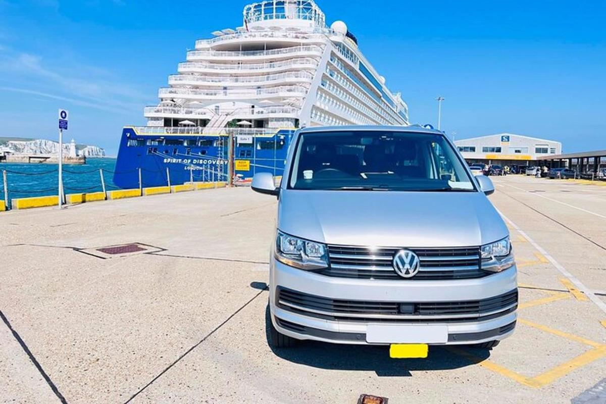a van parked in a parking lot next to a cruise ship