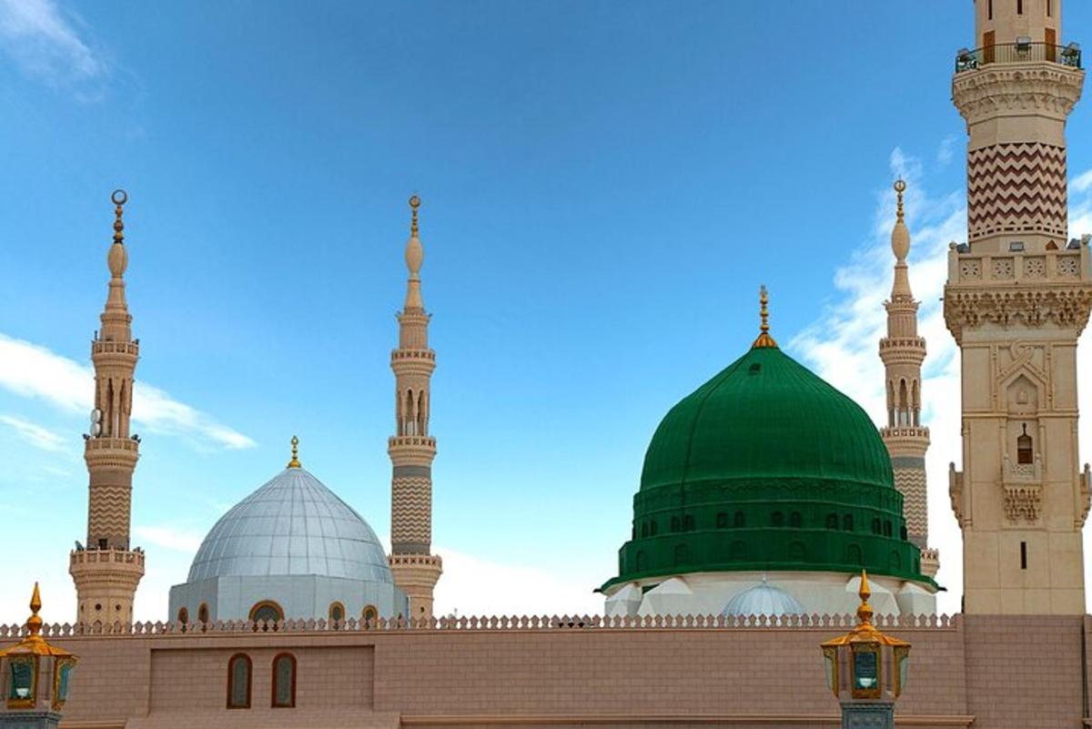 a mosque with a green dome and two domes