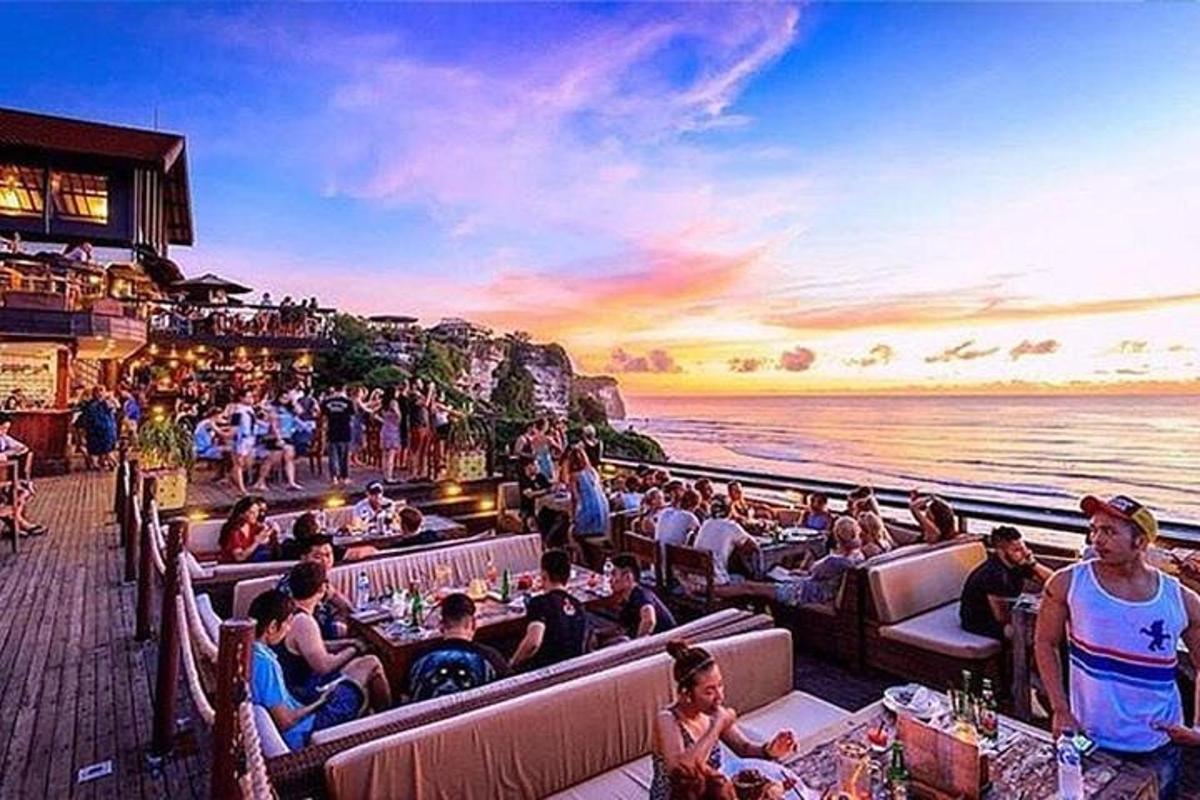 un gruppo di persone sedute in un ristorante vicino all'acqua
