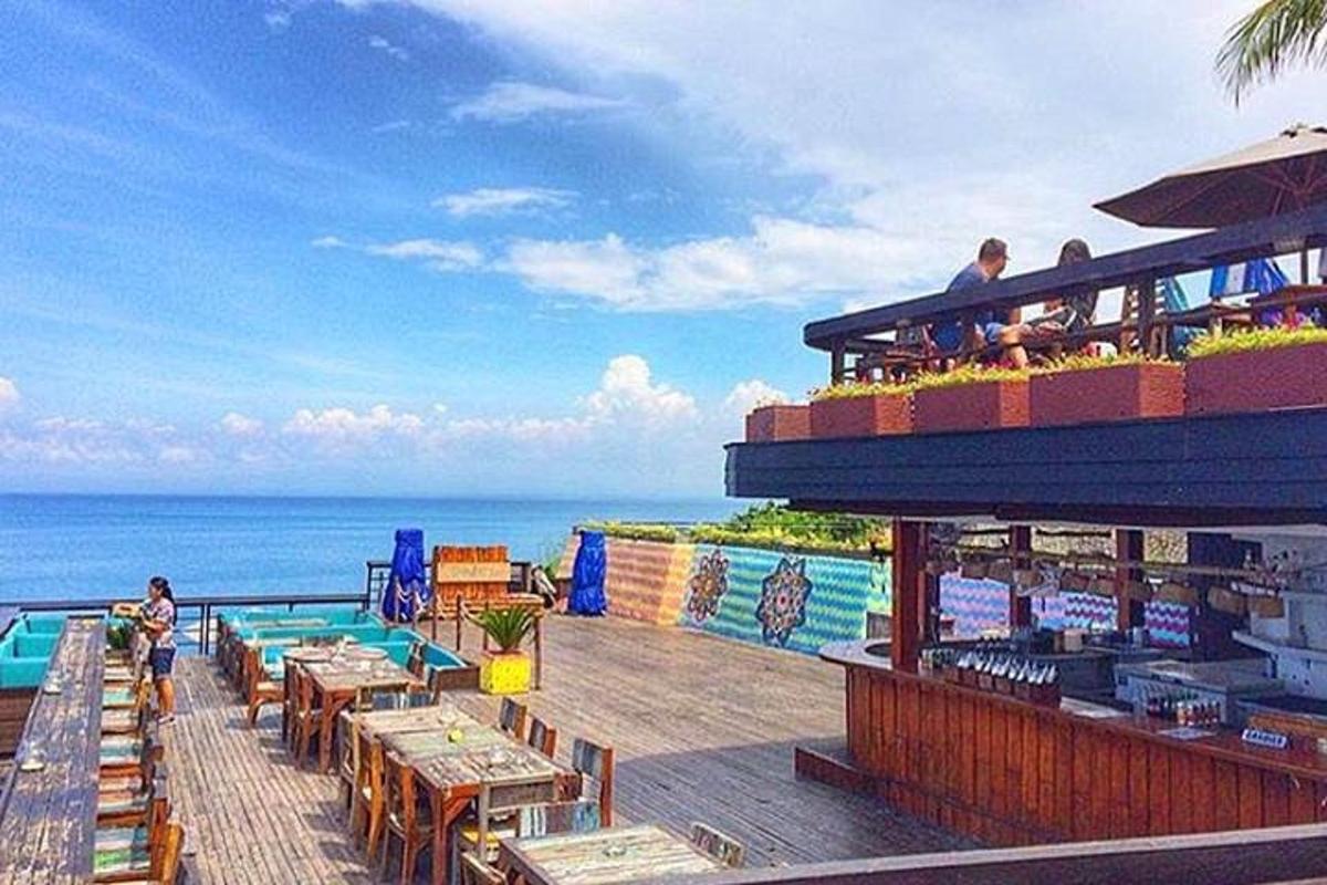 a restaurant with tables and a view of the ocean