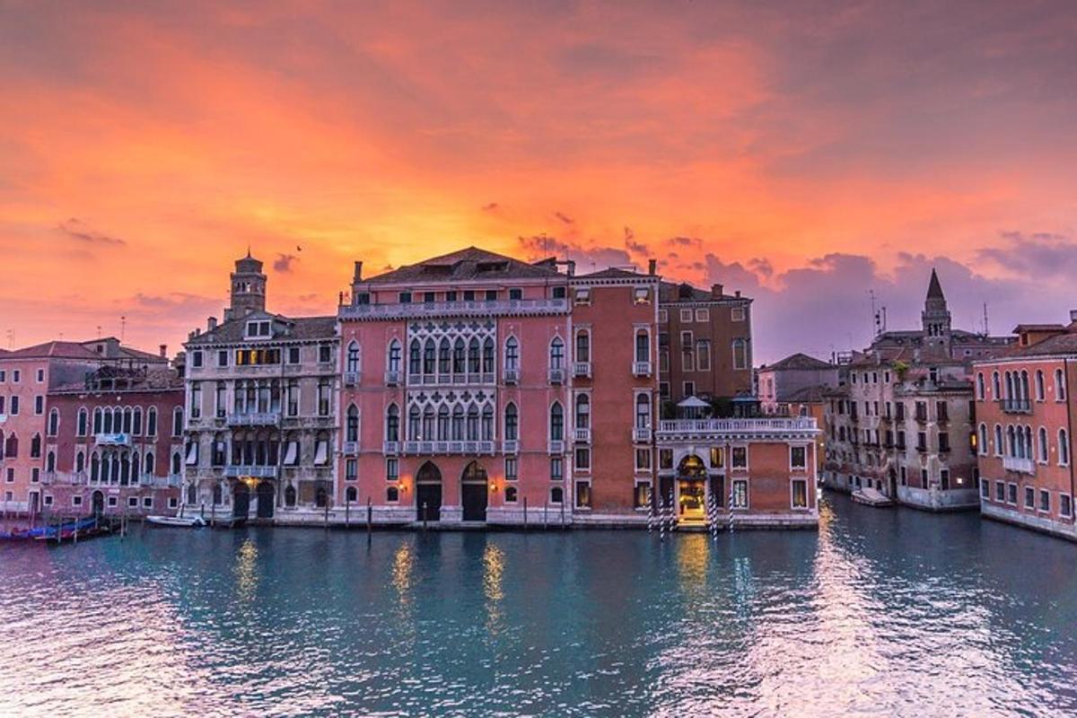 un grup d'edificis a la vora d'un riu amb una posta de sol