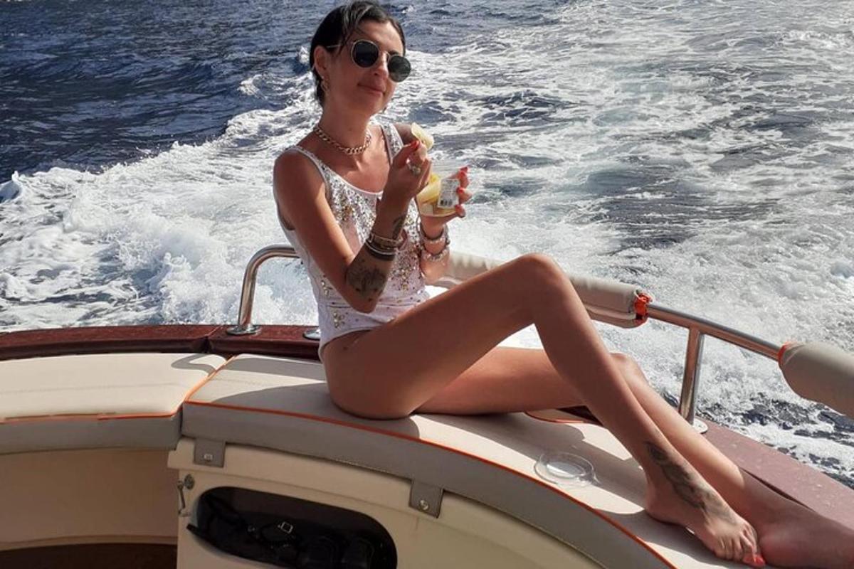 egy nő ül egy hajón és hot dogot eszik
