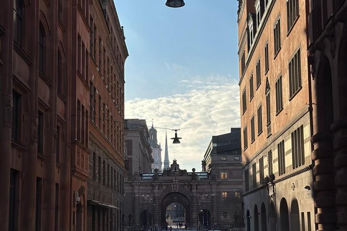 an alley with an archway in a city with buildings