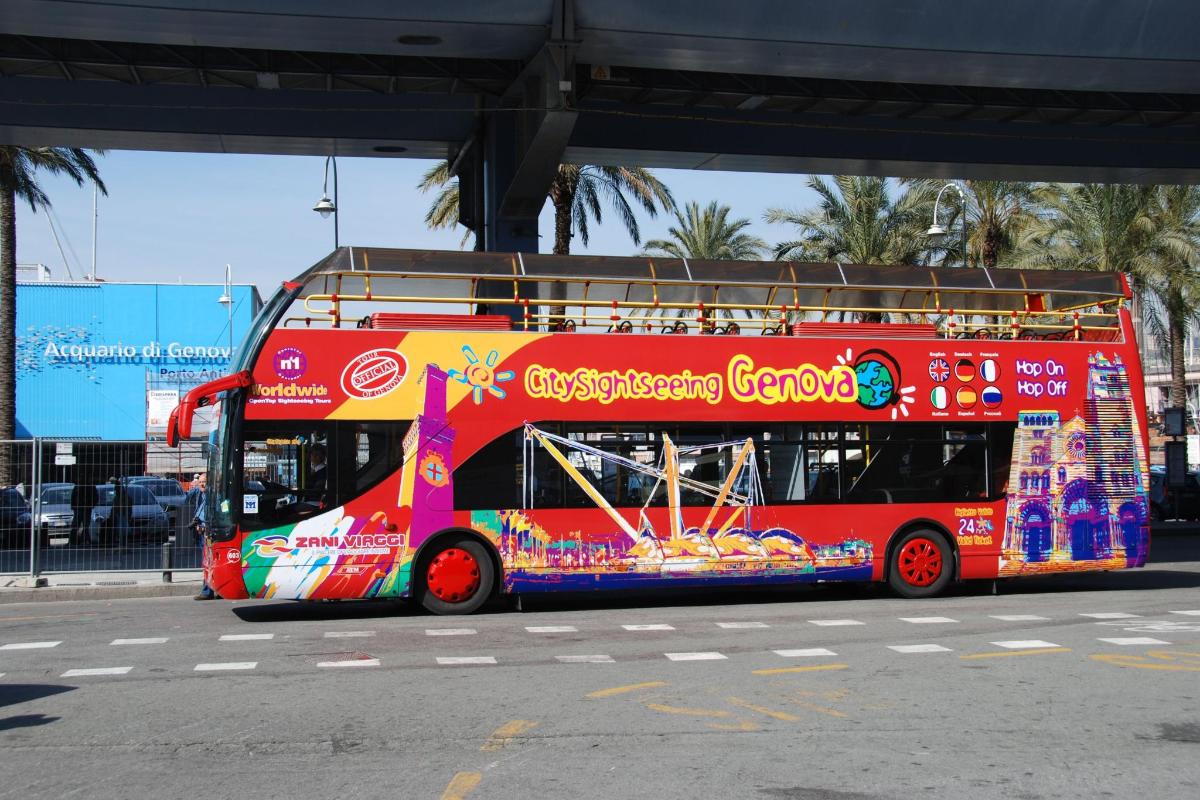 a red double decker bus driving down a street