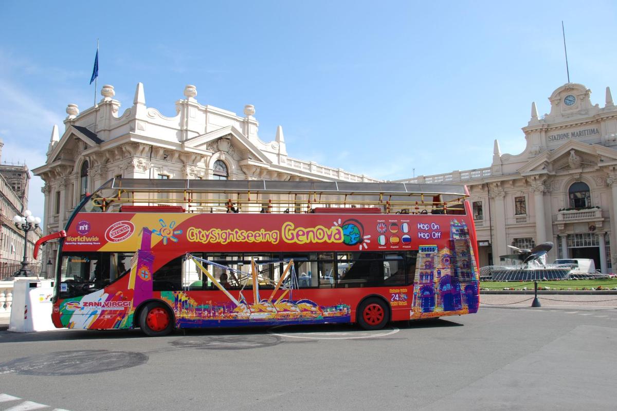 a red double decker bus parked in front of a building