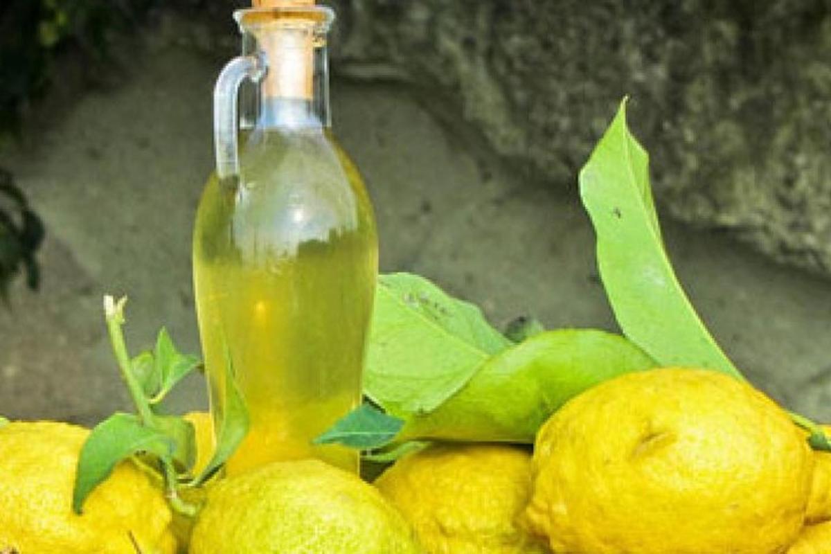 sebotol cairan hijau di atas tumpukan lemon
