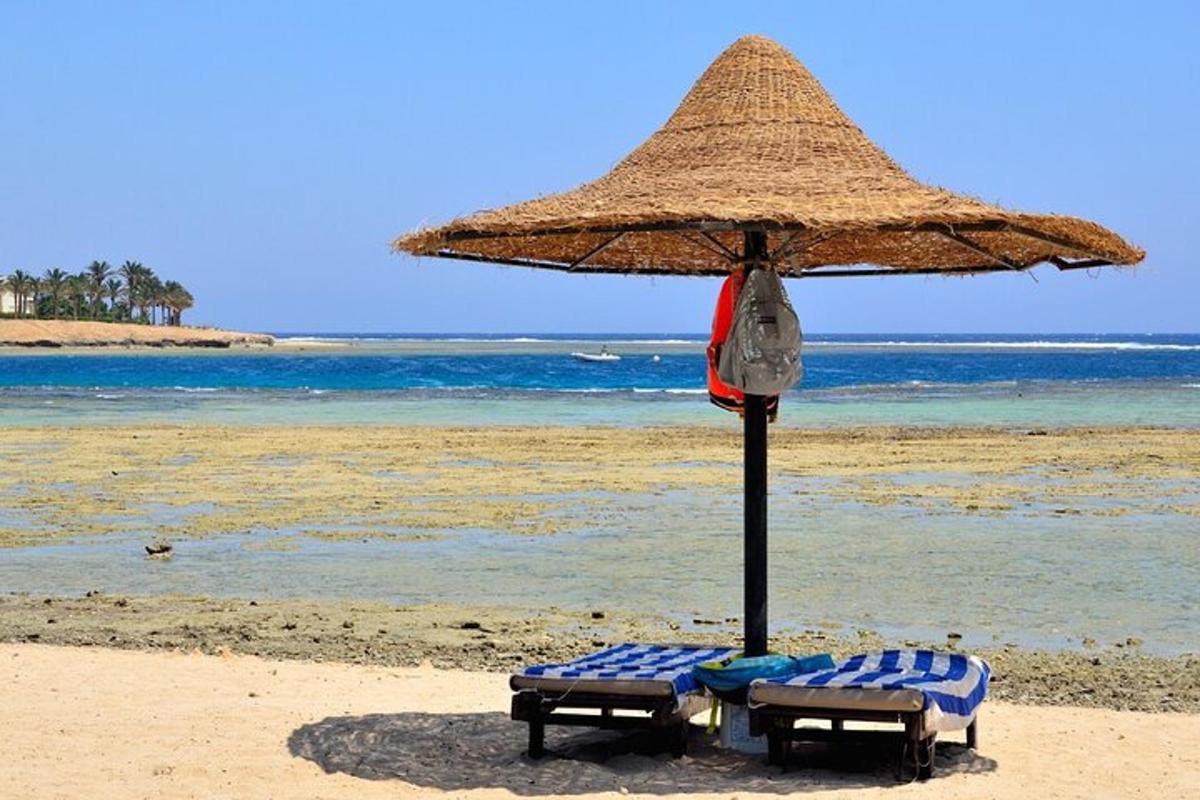 μια ψάθινη ομπρέλα και δύο καρέκλες σε μια παραλία