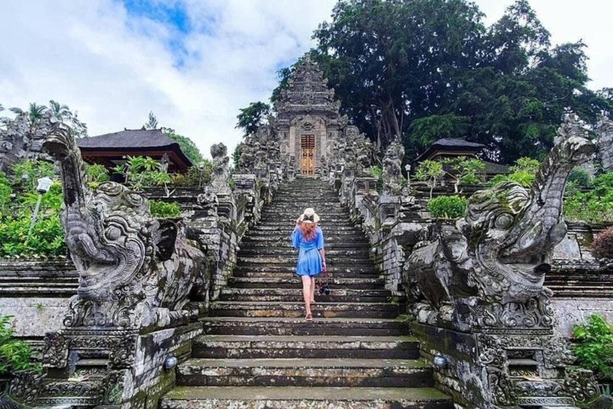 Una mujer con un vestido azul subiendo unas escaleras.