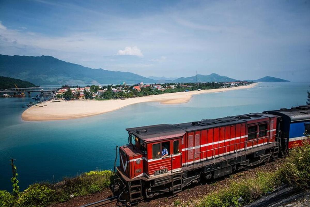 un treno rosso sui binari accanto a una spiaggia