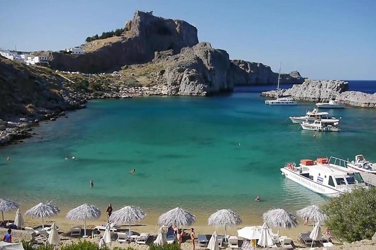 una spiaggia con ombrelloni e una barca in acqua